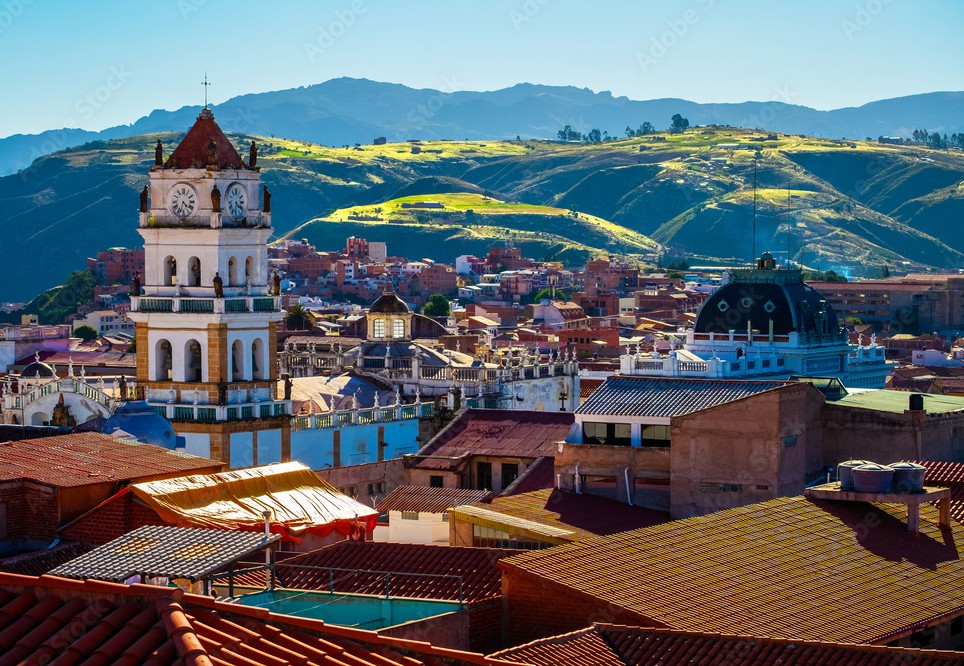 Vista de Sucre con su torre del reloj y colinas al fondo